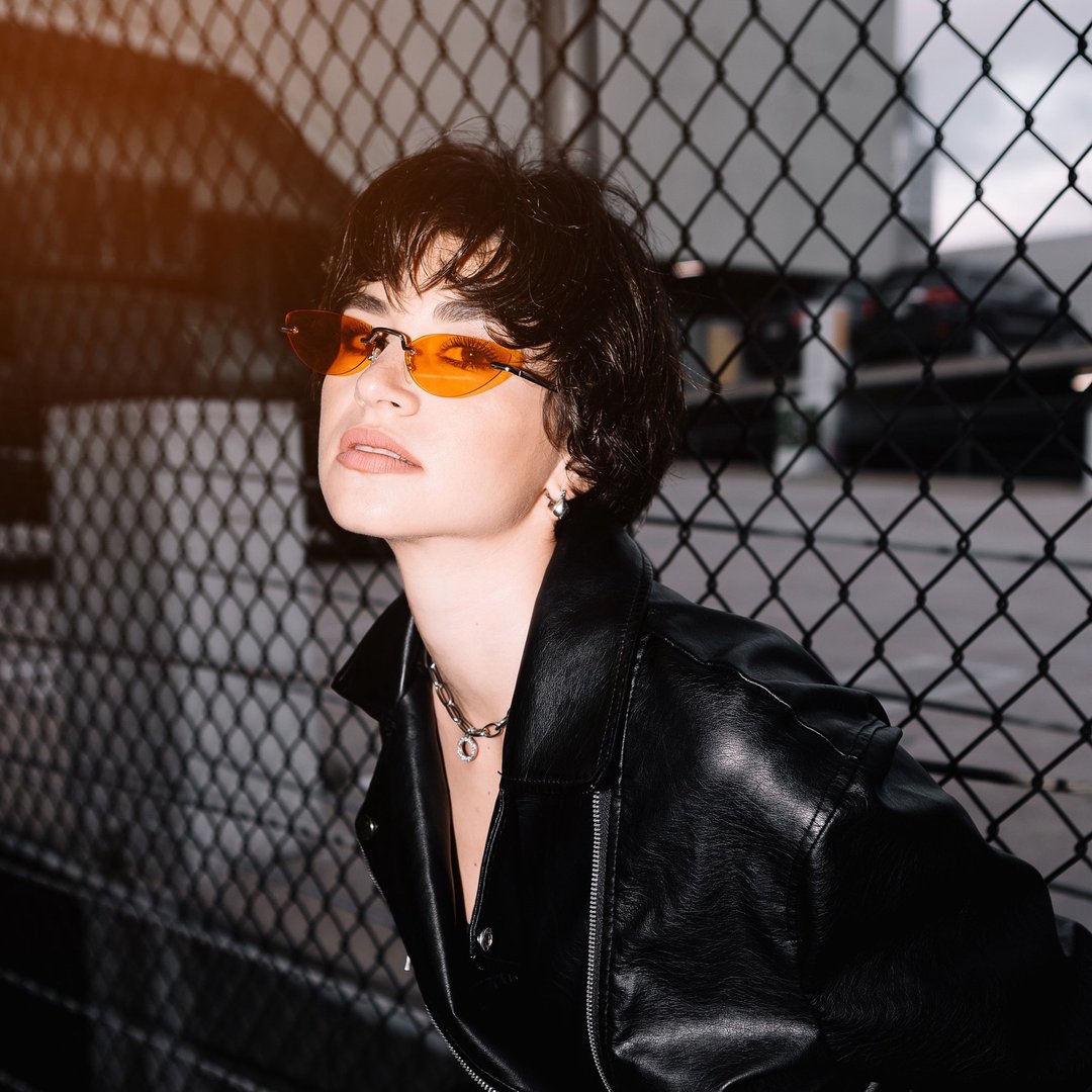 Color portrait of Veronika Erler in orange sunglasses and a black leather jacket